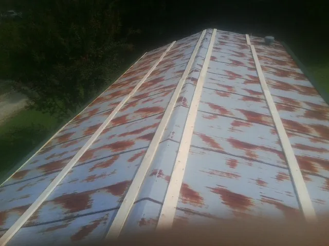 Rusted metal roof panels with new wood purlins before replacement — Storm Damage Roof Repair in Drewryville by Roofing Brothers