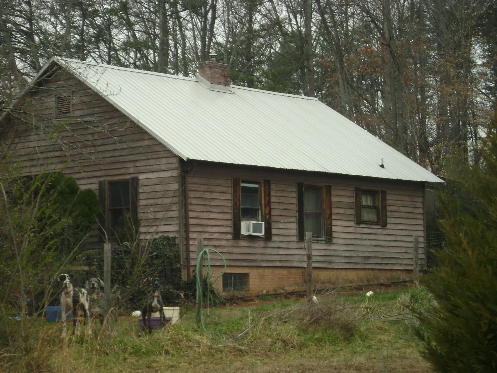 White metal roof on an old wood sided farmhouse, from a Metal Roof Installation job in Drewryville